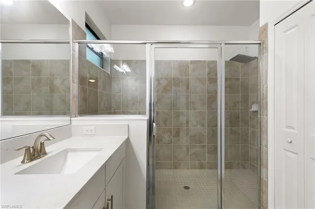 a bathroom with a shower sink and mirror