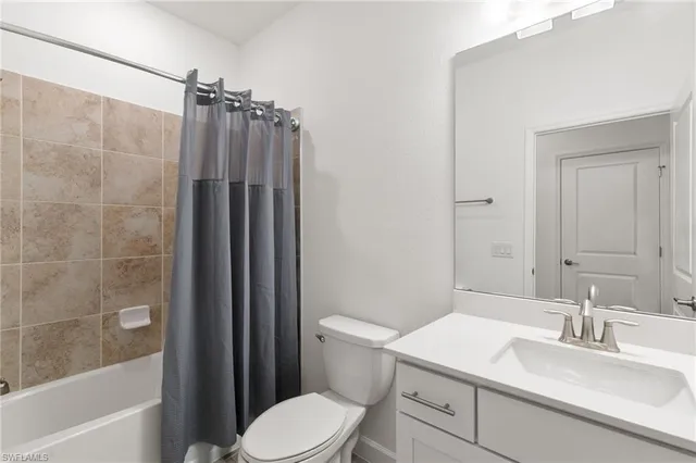 a bathroom with a sink a toilet a mirror and shower