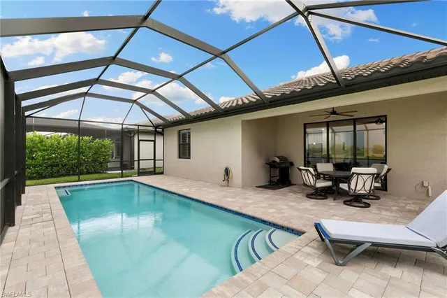 a swimming pool with outdoor seating and yard