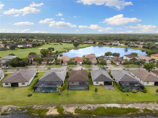 an aerial view of residential houses with outdoor space and ocean view