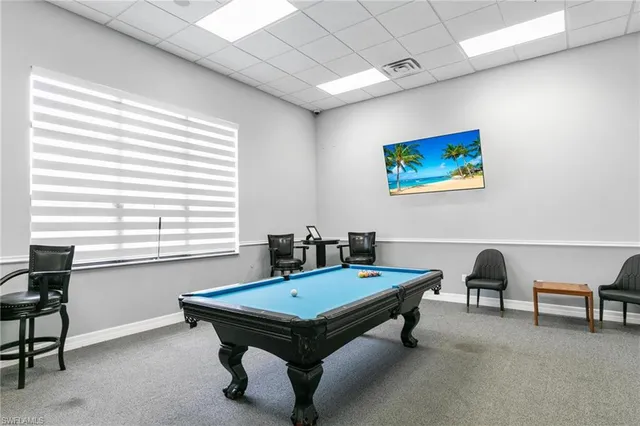 a room with furniture pool table and windows