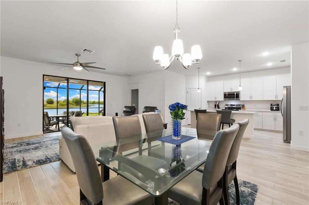 1473 Birdie Drive Naples, FL 34120 - Photo 6 of 50 a view of a dining room with furniture wooden floor and chandelier