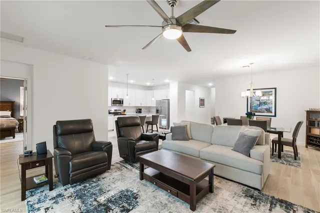 a living room with furniture and a view of kitchen