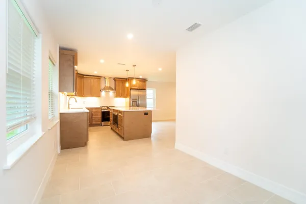 a large white kitchen with kitchen island a large window a sink and counter space