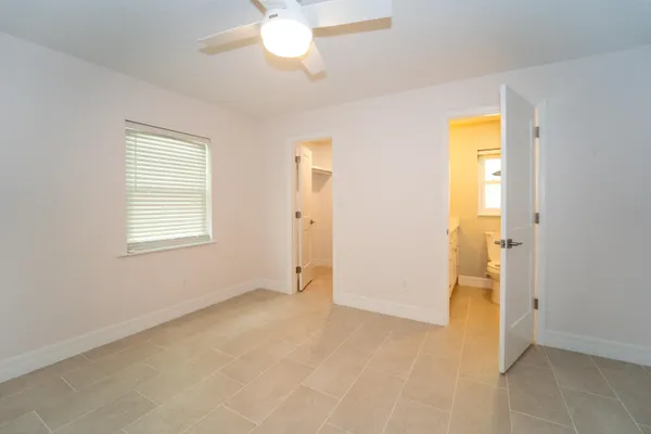 an empty room with closet and a chandelier fan