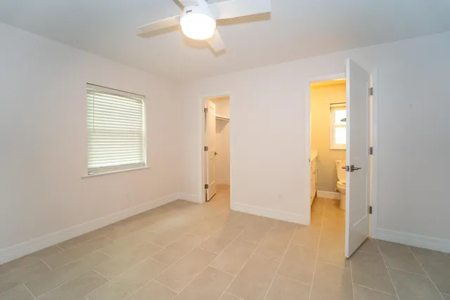 an empty room with closet and a chandelier fan