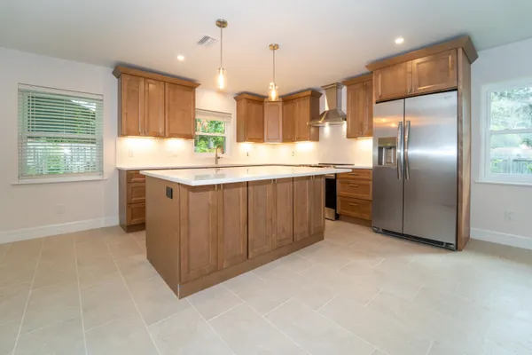 a kitchen with kitchen island granite countertop stainless steel appliances a sink stove and refrigerator