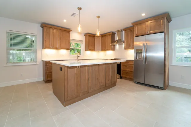 a kitchen with kitchen island granite countertop stainless steel appliances a sink stove and refrigerator