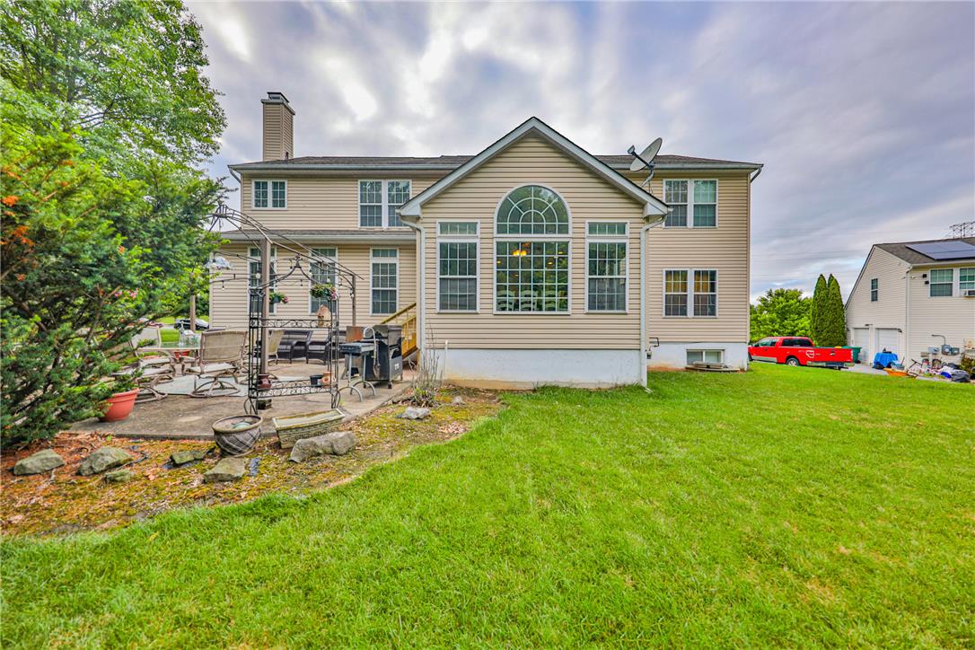 138 Clover Hollow Road Easton, PA 18045 - Photo 79 of 95 A well-maintained lawn extends to a spacious patio, perfect for outdoor entertaining.
