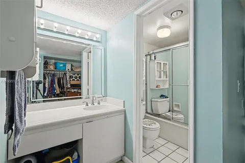 a bathroom with a toilet a sink a mirror and a shower