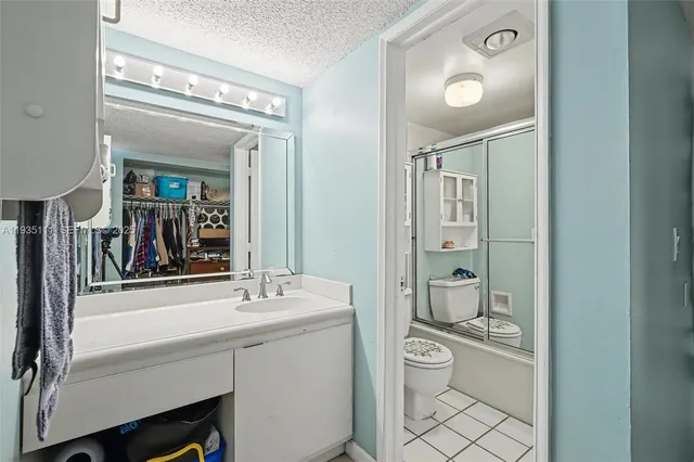 a bathroom with a toilet a sink a mirror and a shower