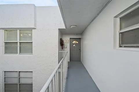 a hallway with front door and wooden floor