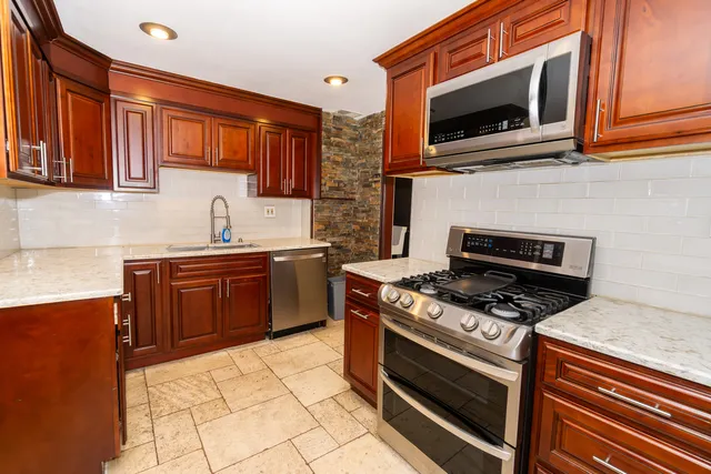 a kitchen with stainless steel appliances a stove a sink and a microwave