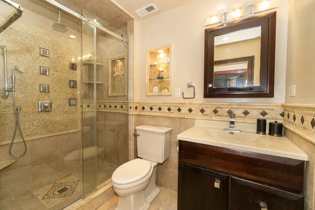 a bathroom with a sink toilet mirror and shower