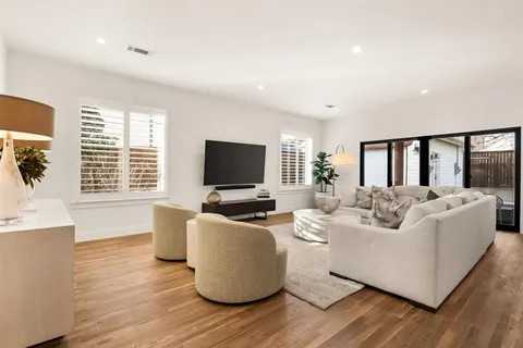 a kitchen with stainless steel appliances granite countertop a stove a sink dishwasher and white cabinets with wooden floor