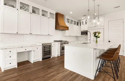 a kitchen with a sink cabinets and wooden floor