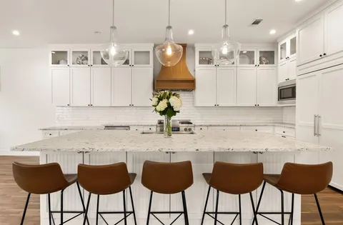 a kitchen with stainless steel appliances granite countertop a sink a stove and a refrigerator