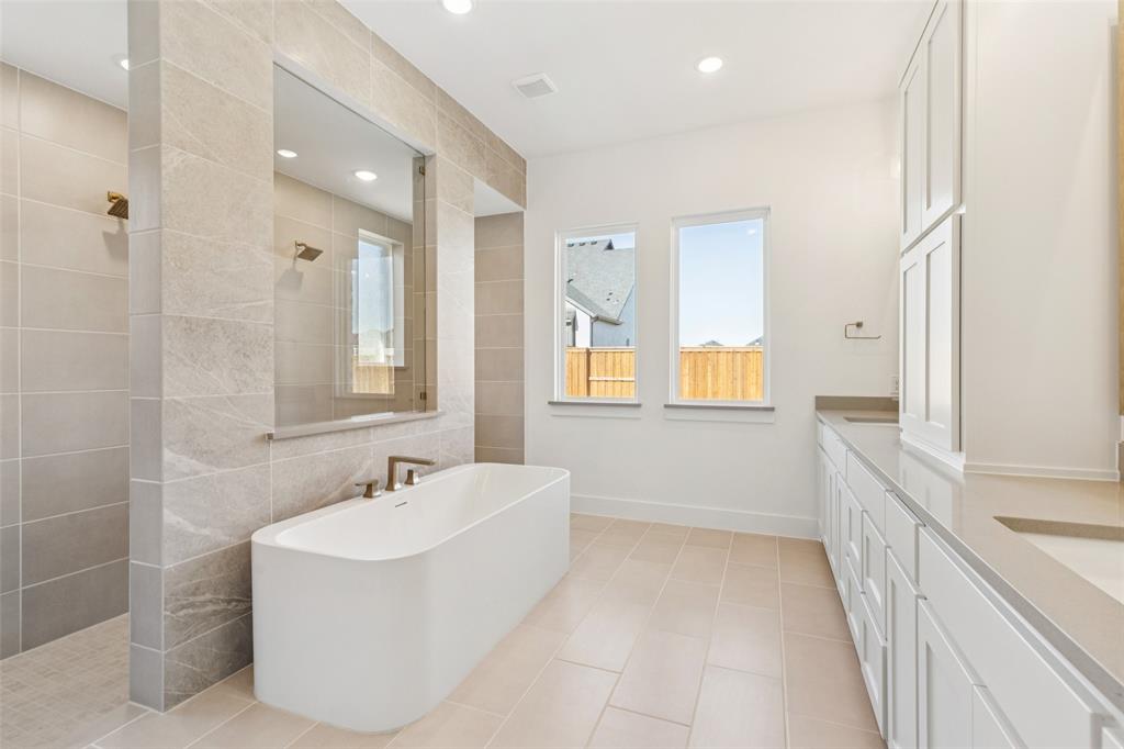 4050 Gambel Road Prosper, TX 75078 - Photo 14 of 23 Featuring a walk through double shower, drying space and a free standing tub, you'll enjoy a spa like experience every day in this luxurious owner's bath!