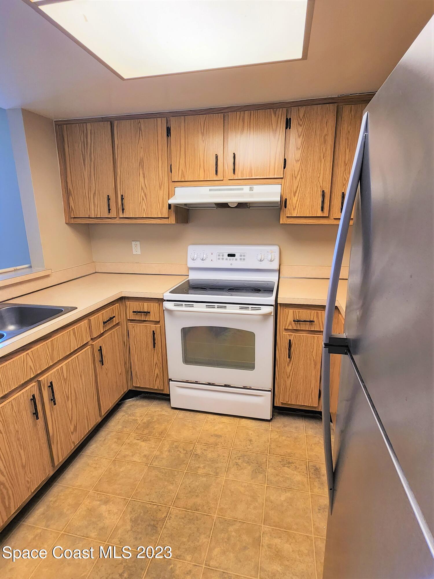 2939 Regency Drive Melbourne, FL 32935 - Photo 19 of 39 a kitchen with stainless steel appliances granite countertop a stove a sink dishwasher and a refrigerator