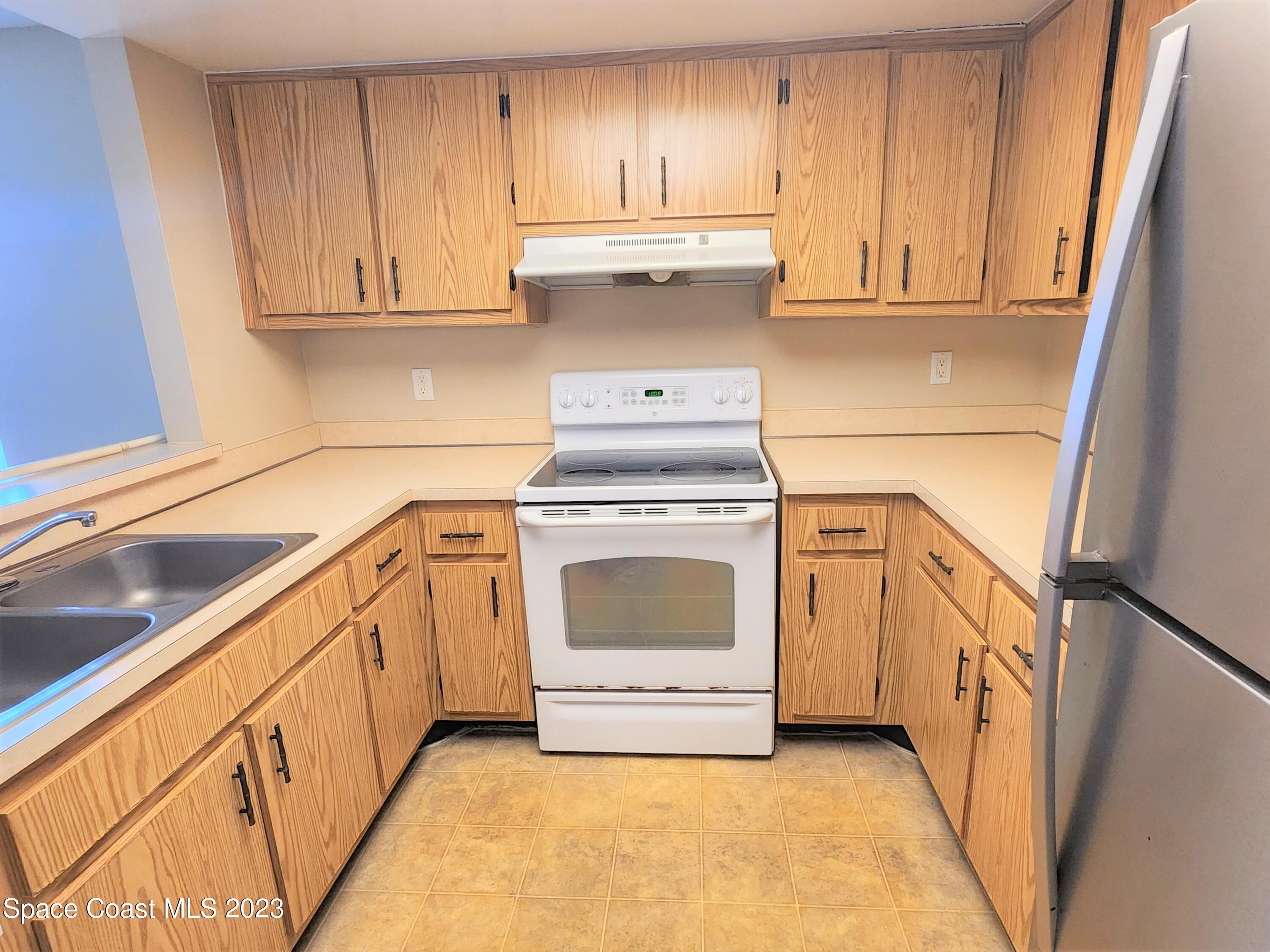2939 Regency Drive Melbourne, FL 32935 - Photo 20 of 39 a kitchen with granite countertop white cabinets and white appliances