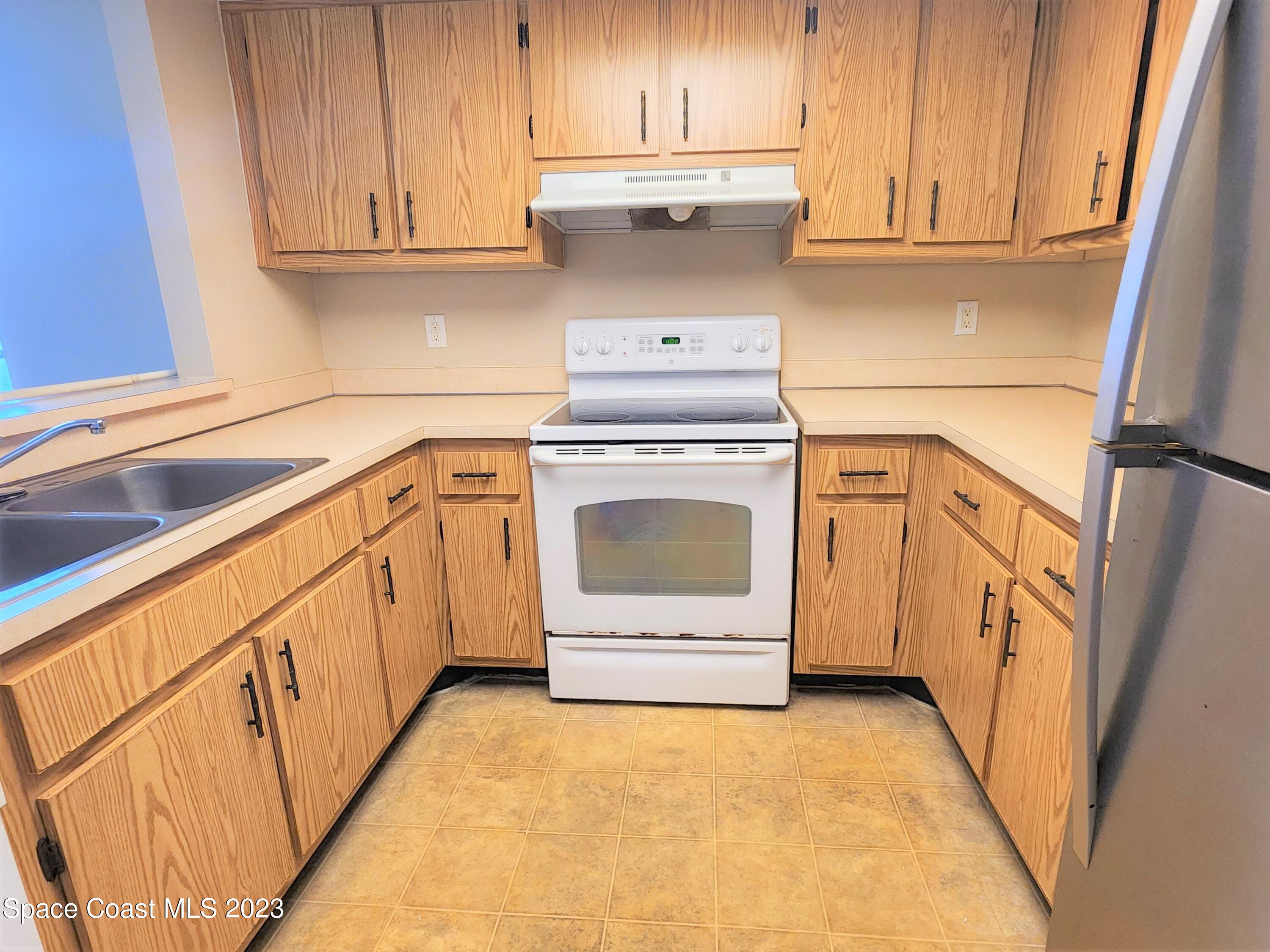 2939 Regency Drive Melbourne, FL 32935 - Photo 21 of 39 a kitchen with white cabinets and white appliances