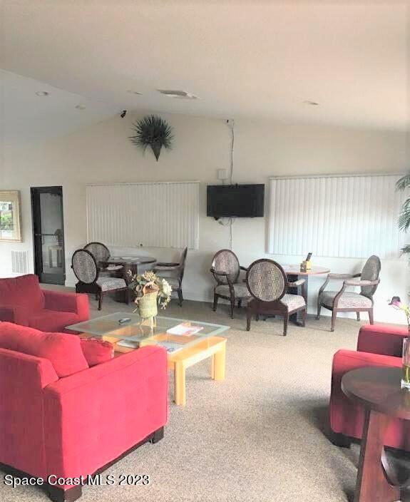 2939 Regency Drive Melbourne, FL 32935 - Photo 27 of 39 a living room with furniture a chandelier and a flat screen tv