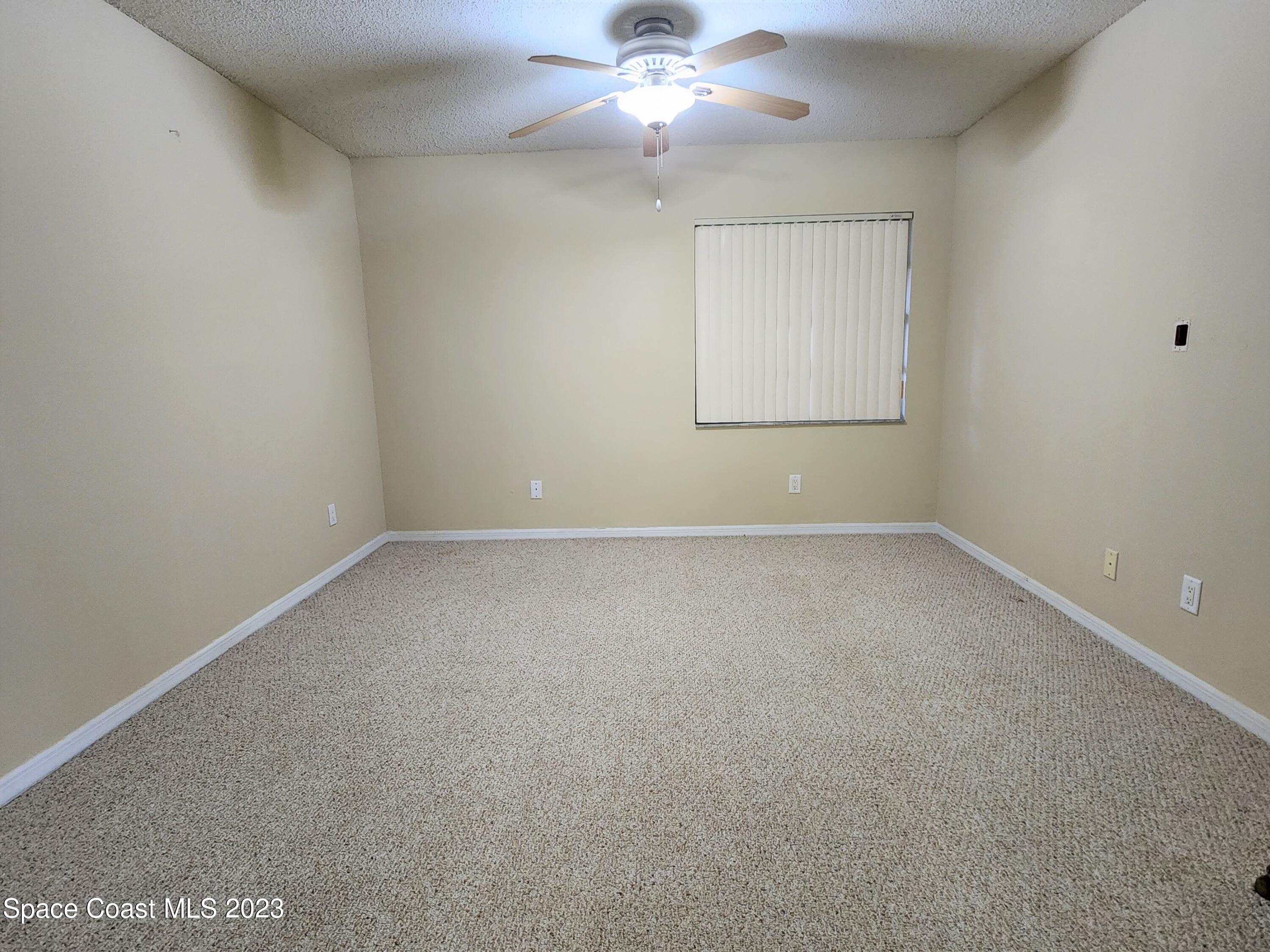 2939 Regency Drive Melbourne, FL 32935 - Photo 9 of 39 an empty room with a window and a fan