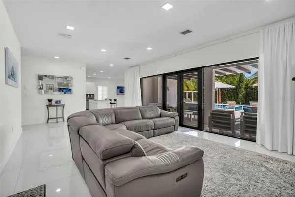 a kitchen with stainless steel appliances granite countertop a refrigerator a stove a sink a dining table and chairs