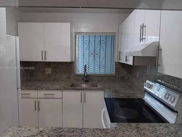 a kitchen with granite countertop a sink and a stove