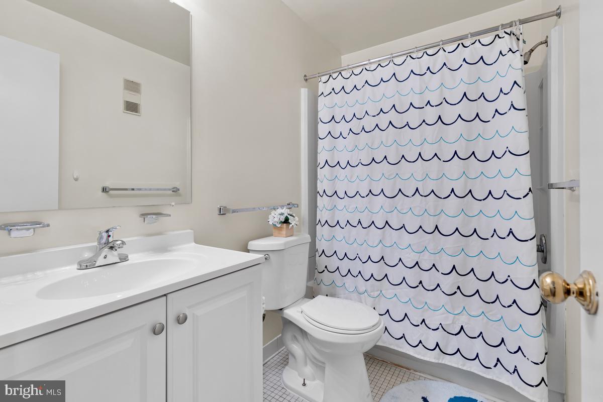 403 South Sharp Street, Unit R 2 Baltimore, MD 21201 - Photo 10 of 15 a bathroom with a sink a toilet and a shower curtain