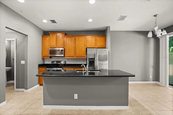 a kitchen with stainless steel appliances granite countertop a sink and a refrigerator