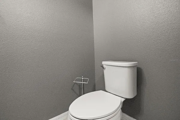 a white toilet sitting next to a white wall