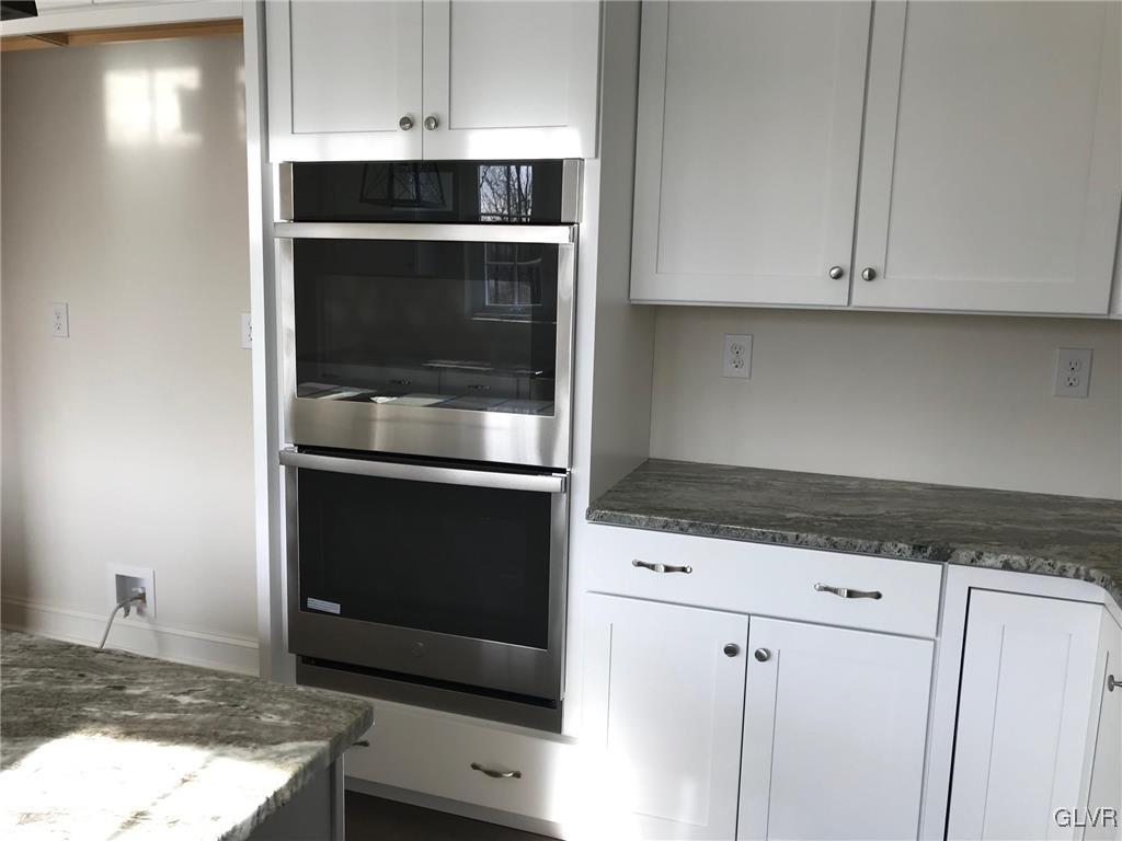 309 Aubrey Road, Unit 18 Nazareth, PA 18064 - Photo 6 of 13 a kitchen with granite countertop white cabinets and stainless steel appliances