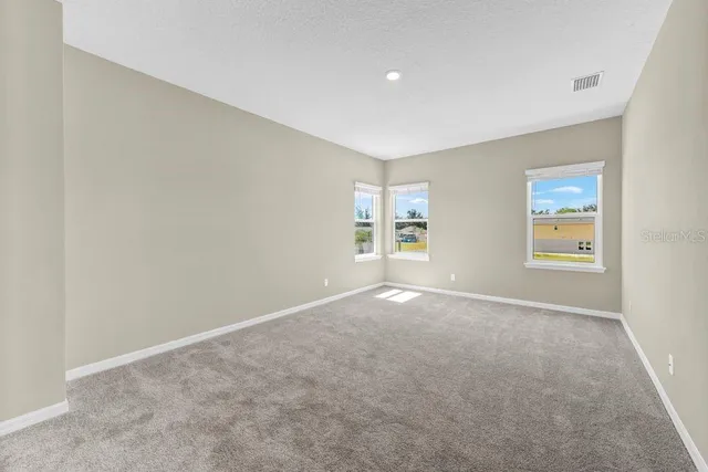 a view of a big room with windows and chandelier fan