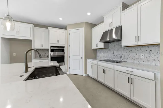 a kitchen with stainless steel appliances a sink stove and cabinets