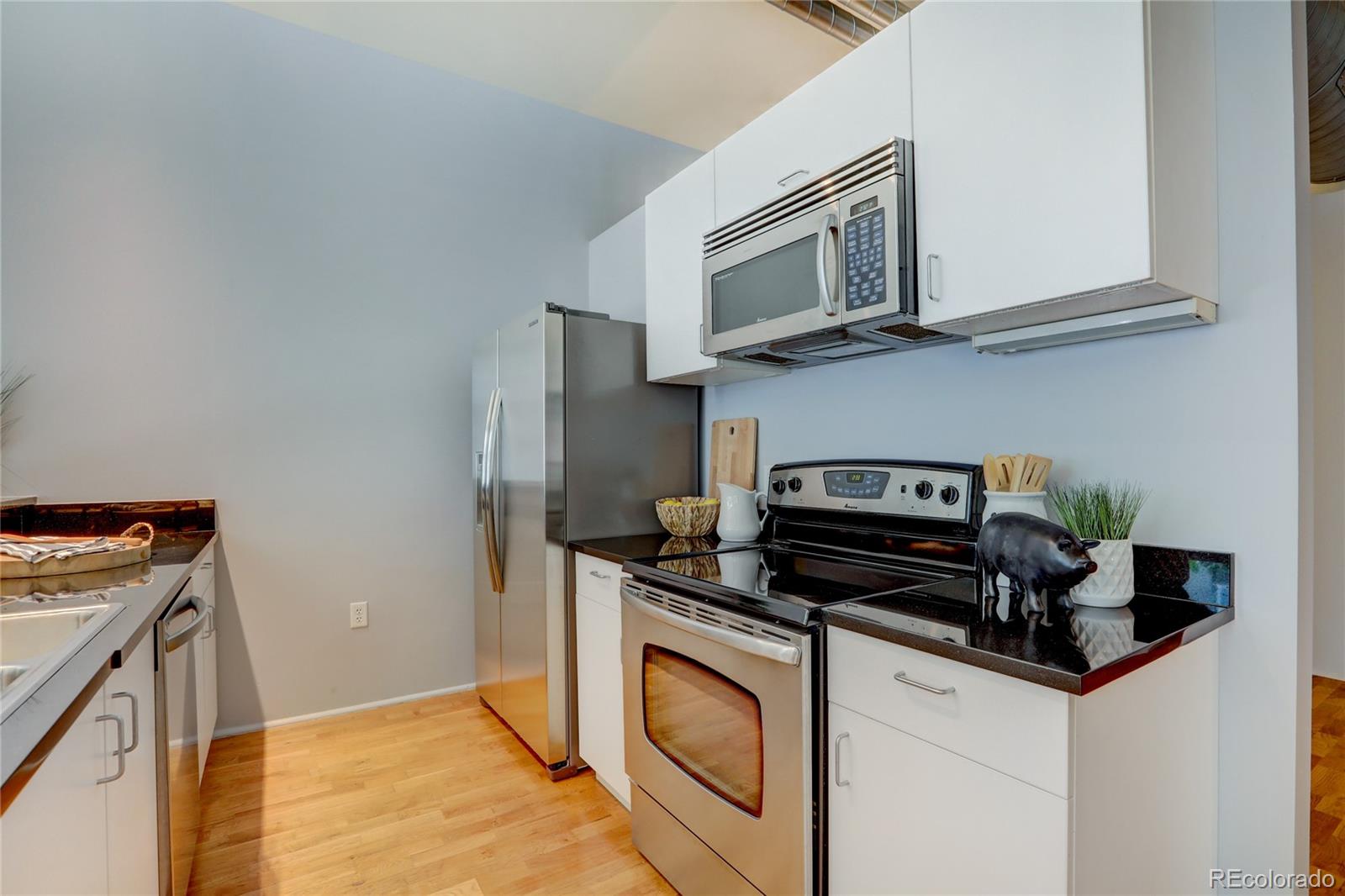 3100 Huron Street, Unit 2R Denver, CO 80202 - Photo 22 of 33 a kitchen with stainless steel appliances granite countertop a stove and a microwave