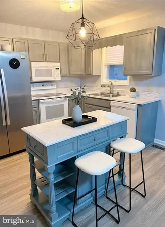 a kitchen with a dining table chairs and white cabinets