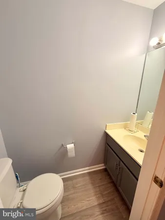 a bathroom with a granite countertop toilet sink and mirror