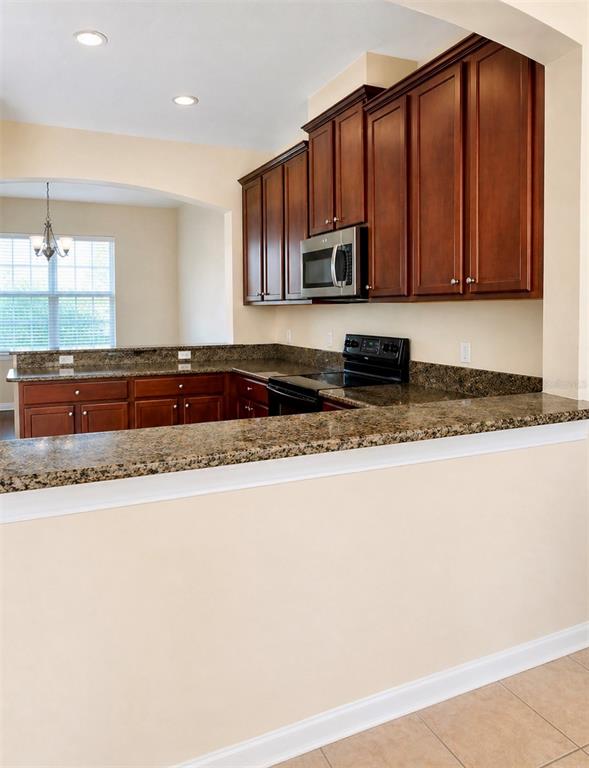 8253 Maritime Flag Street, Unit 109 Windermere, FL 34786 - Photo 12 of 23 a kitchen with stainless steel appliances granite countertop a stove a sink and a microwave