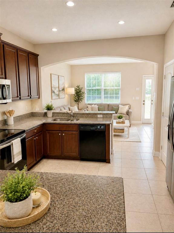 8253 Maritime Flag Street, Unit 109 Windermere, FL 34786 - Photo 10 of 23 a kitchen with stainless steel appliances granite countertop a stove a sink and a microwave