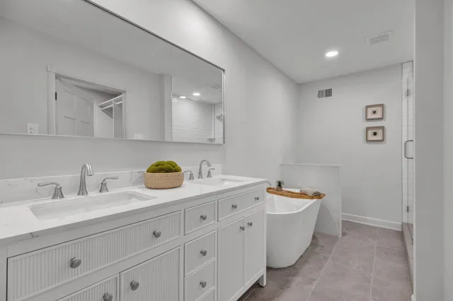 a bathroom with a granite countertop sink and a bathtub