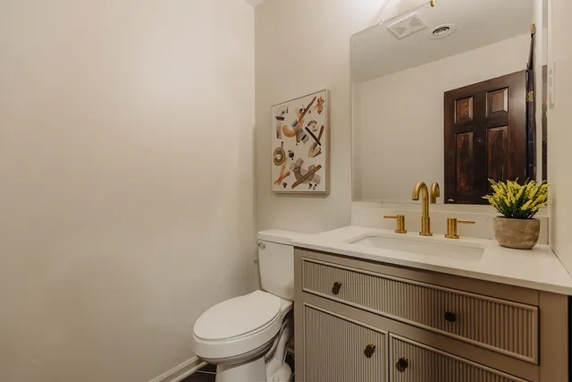 a bathroom with a granite countertop toilet sink and mirror