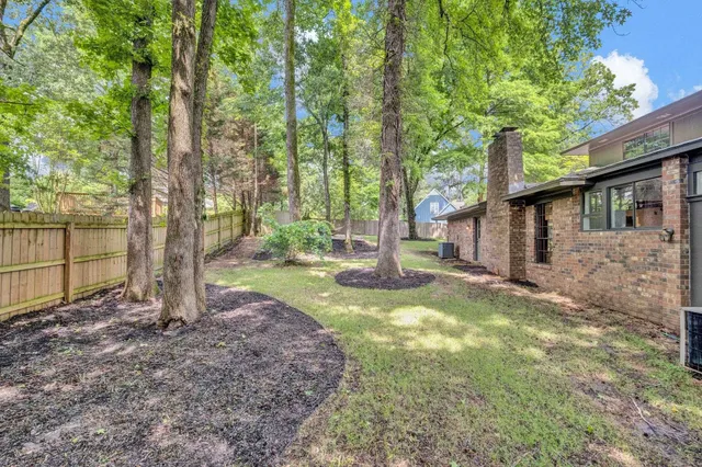 a view of a house with backyard and tree