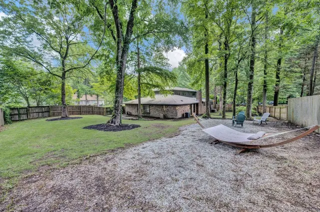 a view of a backyard with large trees