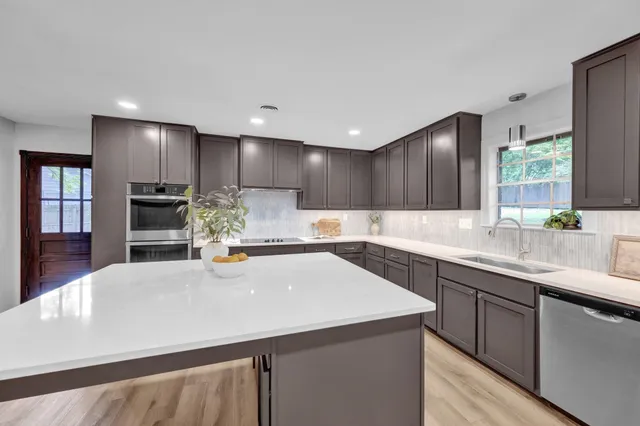 a kitchen with kitchen island a sink and appliances