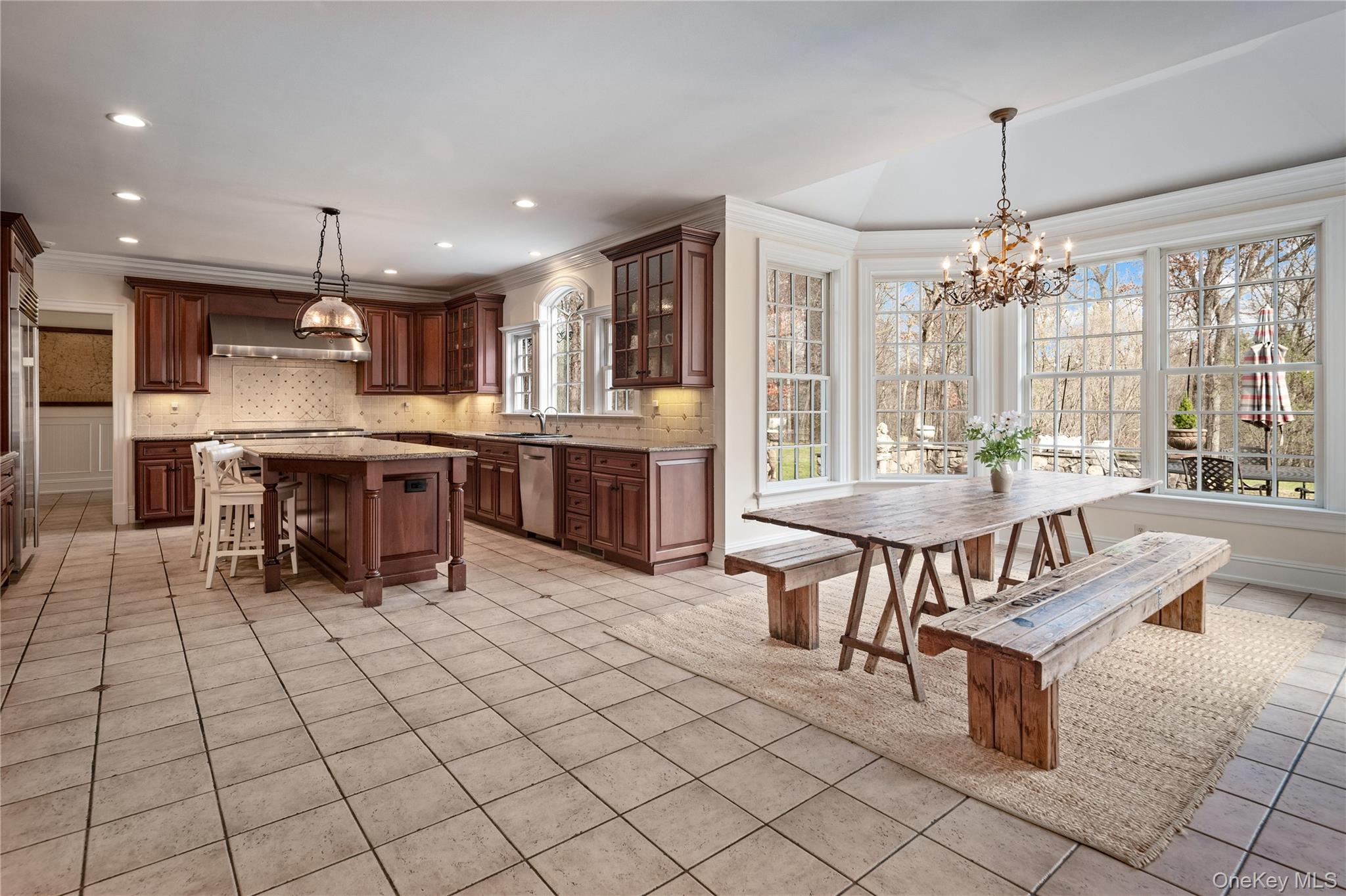 11 Lost Nations Road Pound Ridge, NY 10576 - Photo 15 of 42 a kitchen with stainless steel appliances kitchen island granite countertop a table chairs and a refrigerator