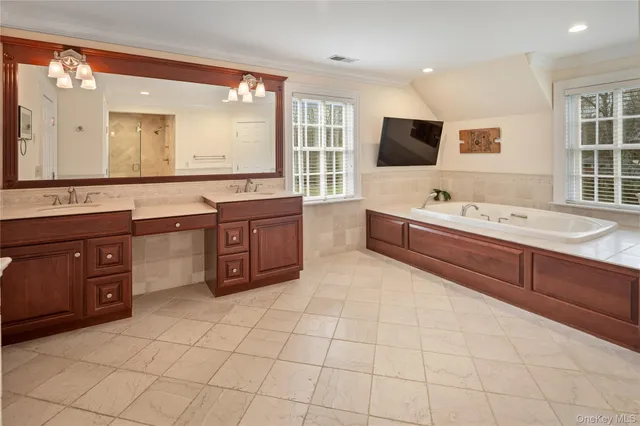 a large bathroom with a granite countertop double vanity sink and a bathtub
