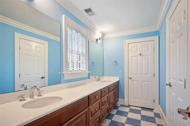 a spacious bathroom with a double vanity sink a mirror and a shower