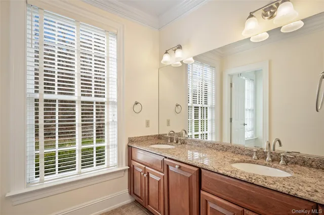 a bathroom with a granite countertop sink a large mirror and a window