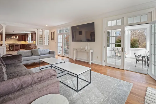 a living room with furniture a flat screen tv and a floor to ceiling window